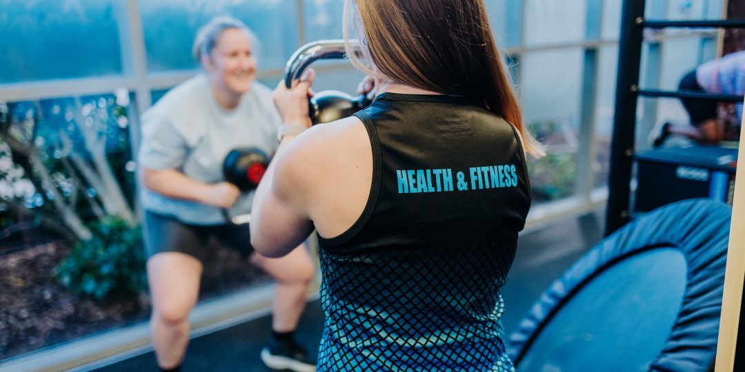 Trainer instructing Client how to use a kettleball